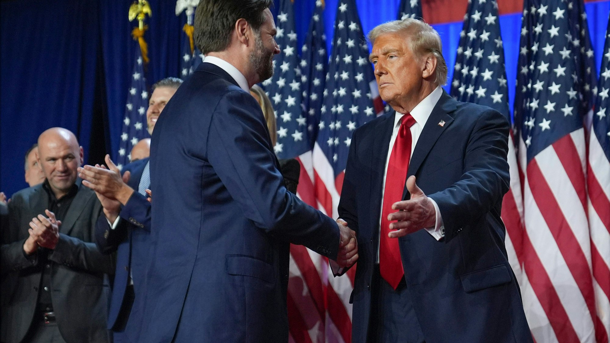 06.11.2024, USA, West Palm Beach: Der republikanische Präsidentschaftskandidat, der ehemalige US-Präsident Donald Trump, begrüßt den republikanischen Vizepräsidentschaftskandidaten, Senator J.D. Vance, R-Ohio, bei einer Wahlparty während der US-Wahlen im Palm Beach Convention Center. Foto: Evan Vucci/AP/dpa +++ dpa-Bildfunk +++