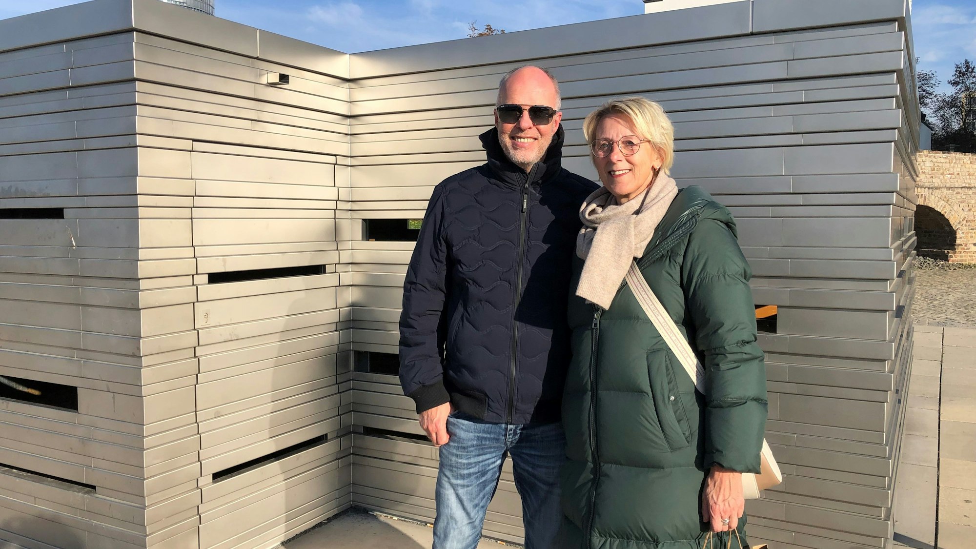 Rita und Jens Hofmann aus Ostfriesland vor der neuen Stahleinhausung für römische Mauerreste auf dem Rheinboulevard.