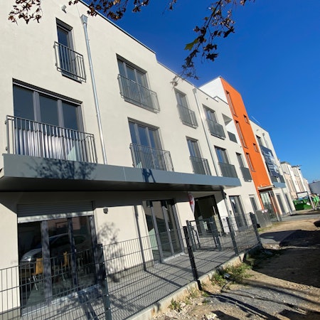 Eine Straßenansicht eines mehrstöckigen Neubaus