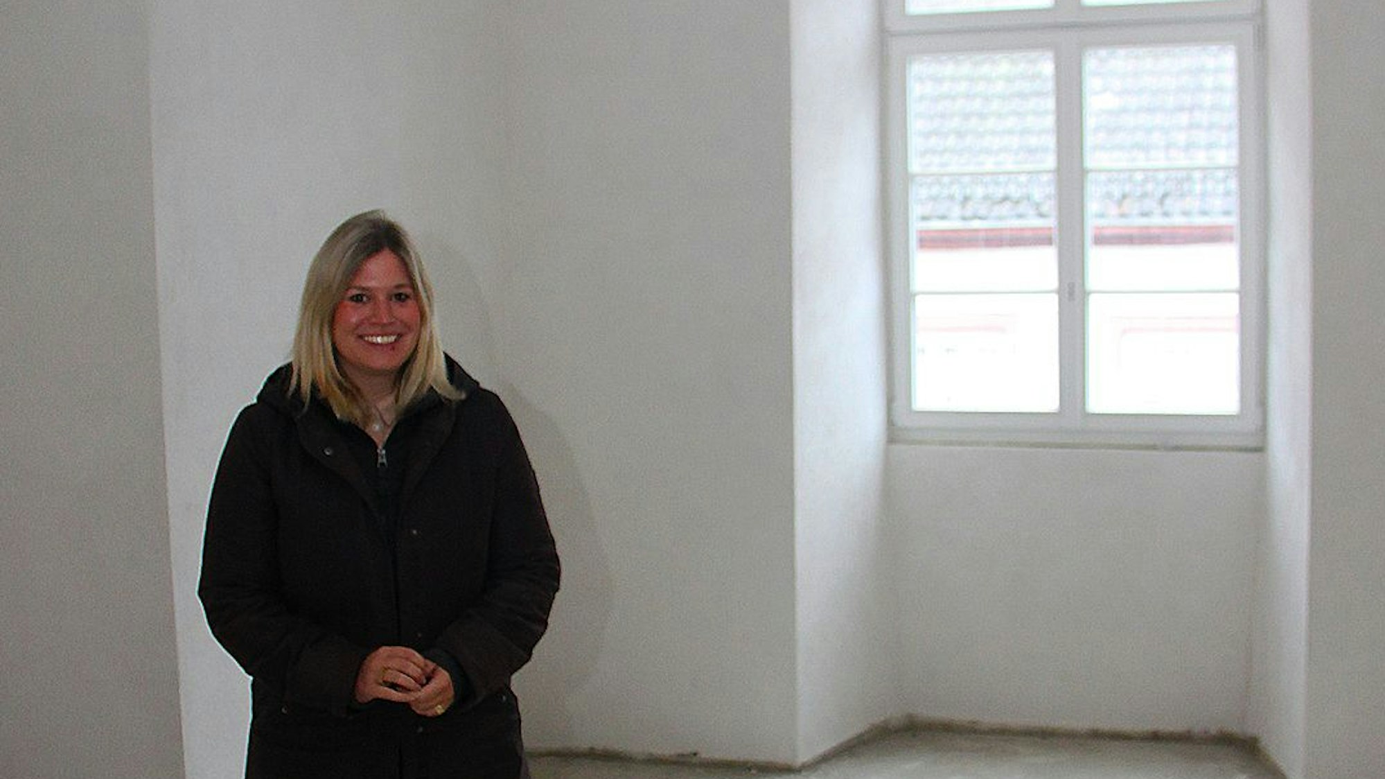 Bürgermeisterin Jennifer Meuren steht in einem Raum mit weißen Wänden. Jetzt ist es noch eine Baustelle, später wird dies ihr Dienstzimmer sein.