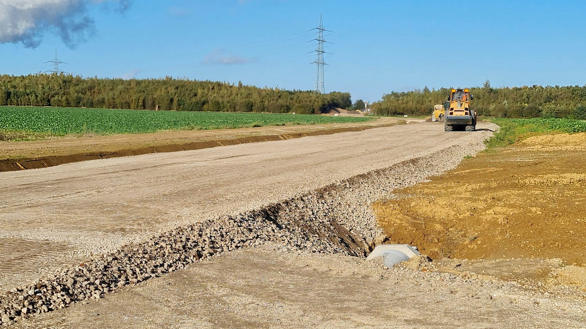 Zu sehen ist eine Trasse für eine Straße, die einen Acker durchschneidet,