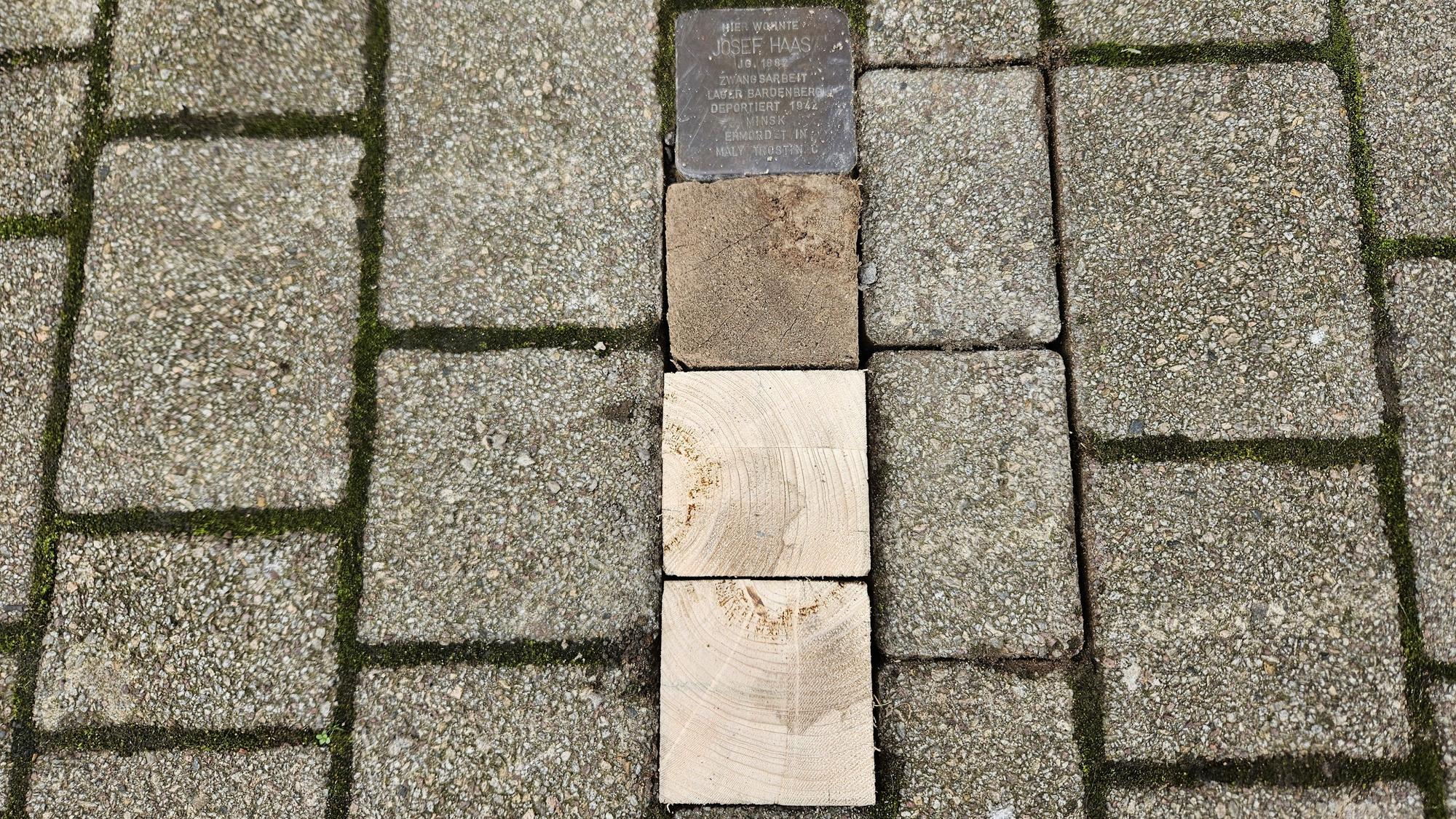 Drei fehlende Steine in der Dreiborner Straße sind durch Stücke aus Holzbalken ersetzt.