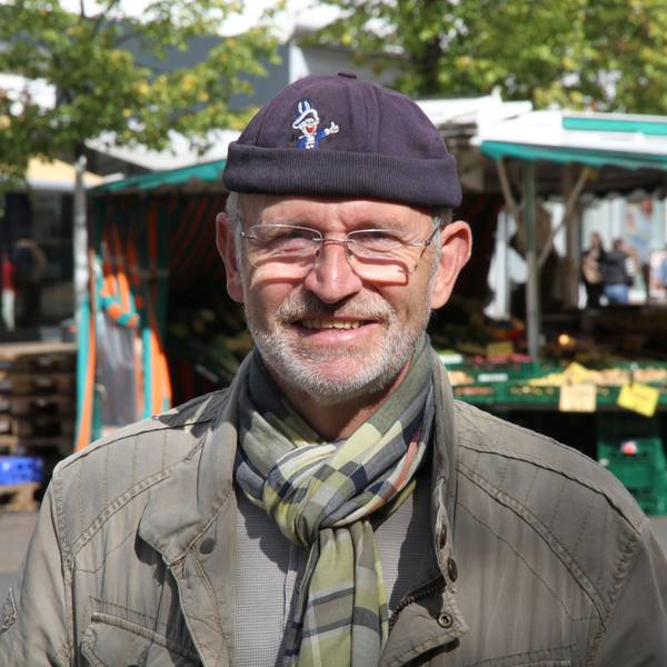 Ein Mann mit Mütze auf einem Marktplatz