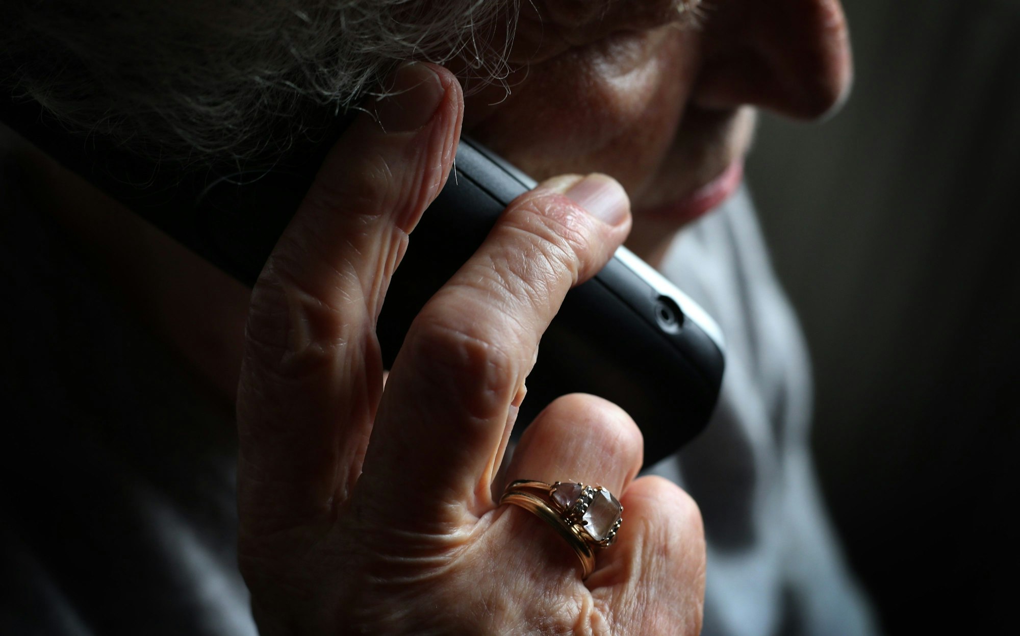 Das Bild zeigt eine Frau, die einen Telefonhörer in der Hand hält.