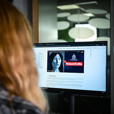 Eine Person sieht sich die Interpol-Website an, die die Seite der „Identify me“-Kampagne zeigt.