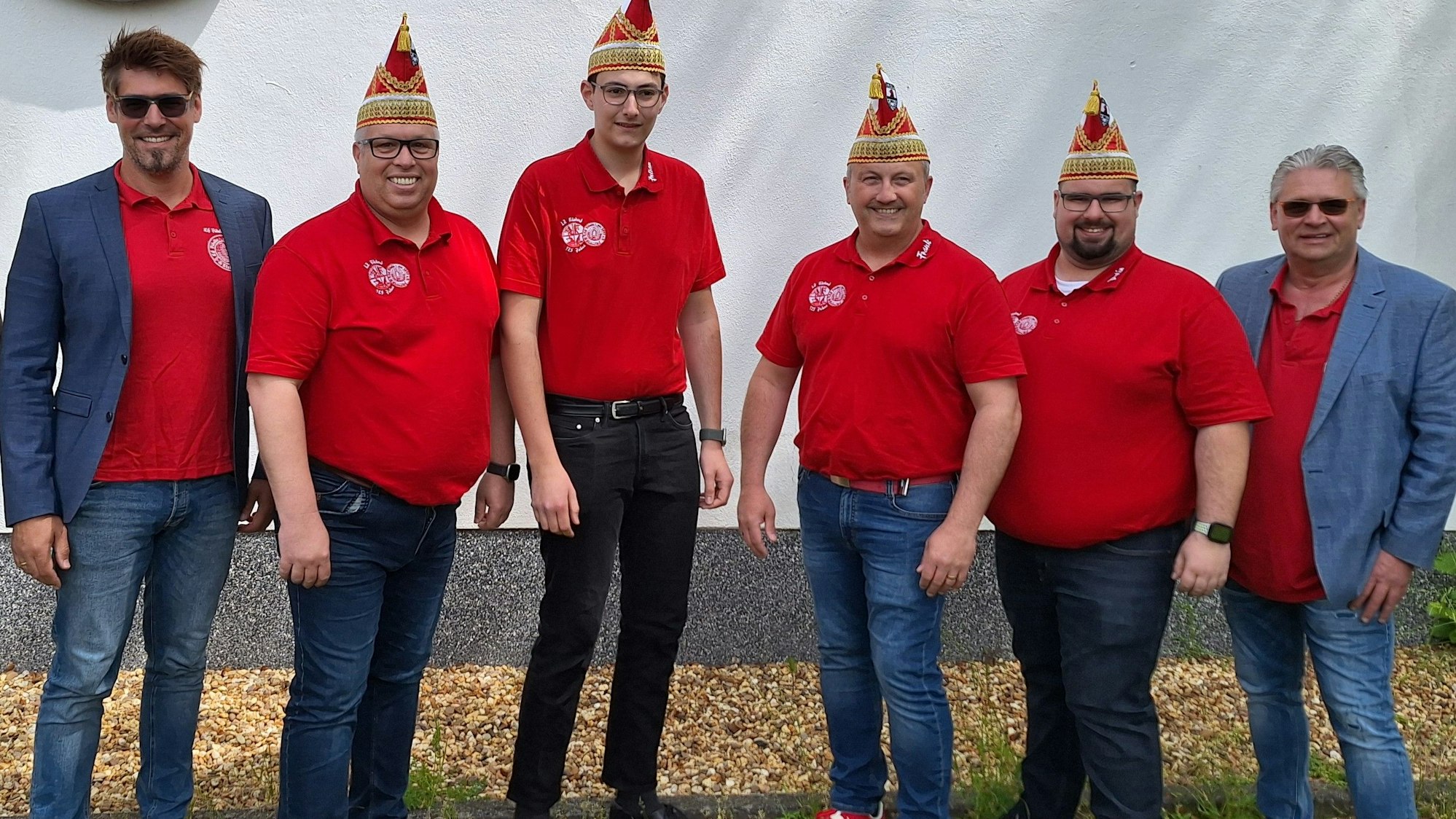 Zu sehen sind sechs Männer, vier davon mit Narrenkappe.