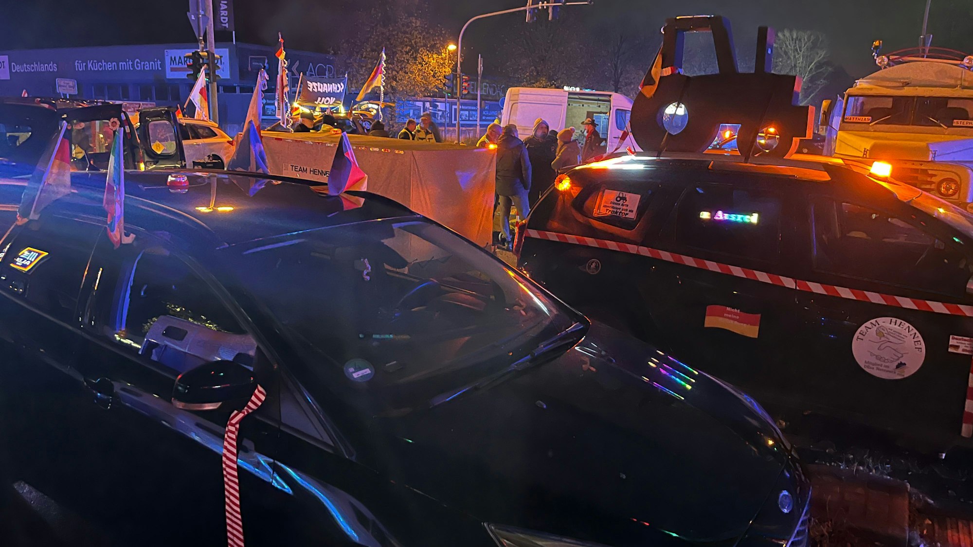 Autos und Menschen stehen auf einer Kreuzung.