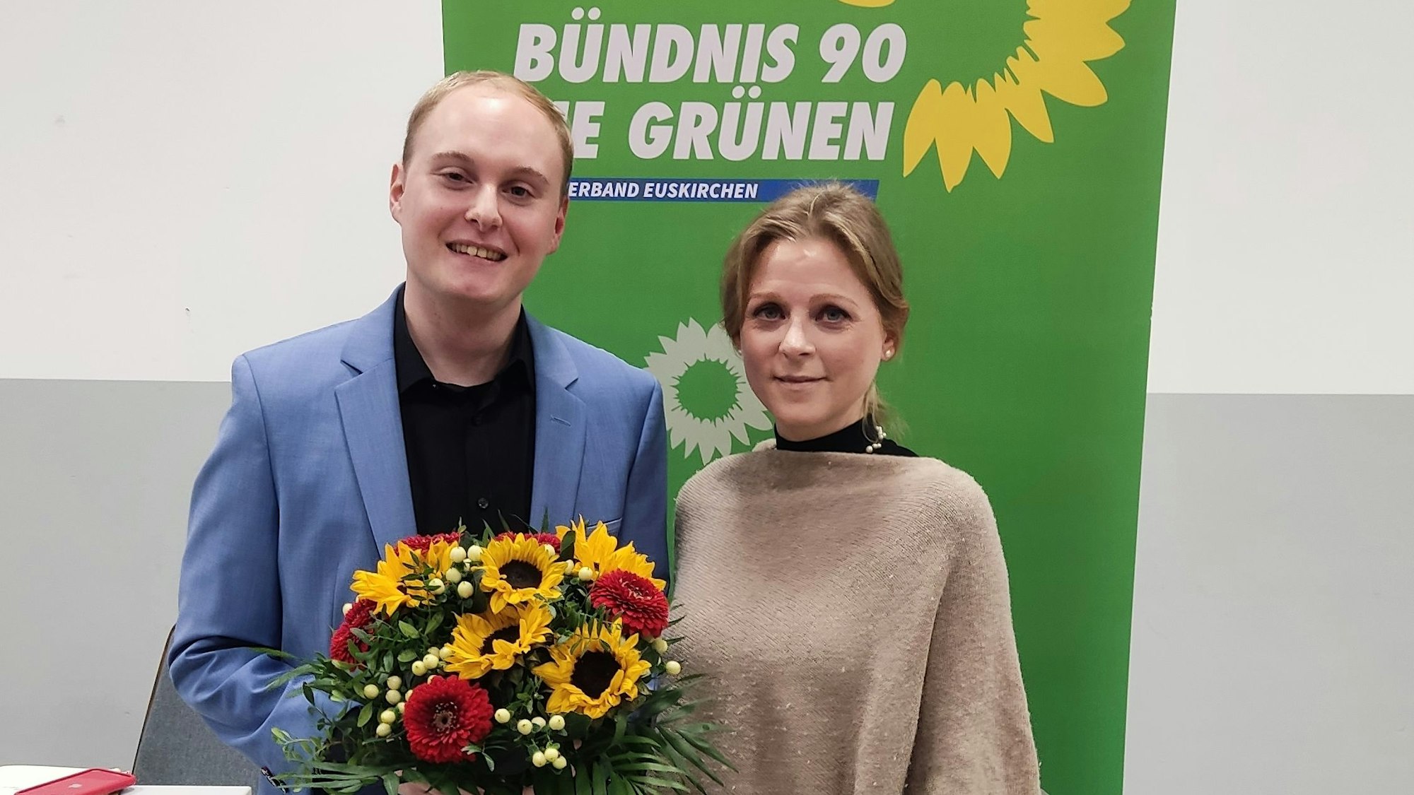 Das Foto zeigt den Kandidaten mit einem Blumenstrauß und die Gratulantin.