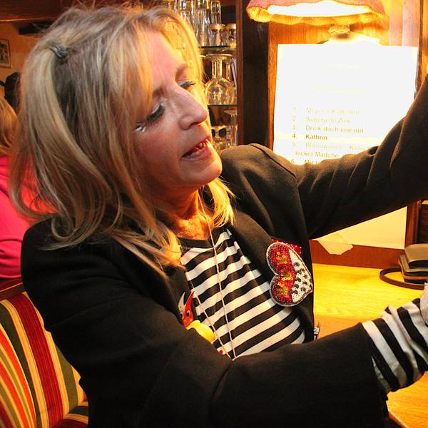 Eine Frau knüpft Kordel um kleine Partywürstchen, die als Karnevalsorden verliehen werden.