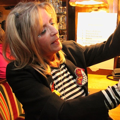 Eine Frau knüpft Kordel um kleine Partywürstchen, die als Karnevalsorden verliehen werden.