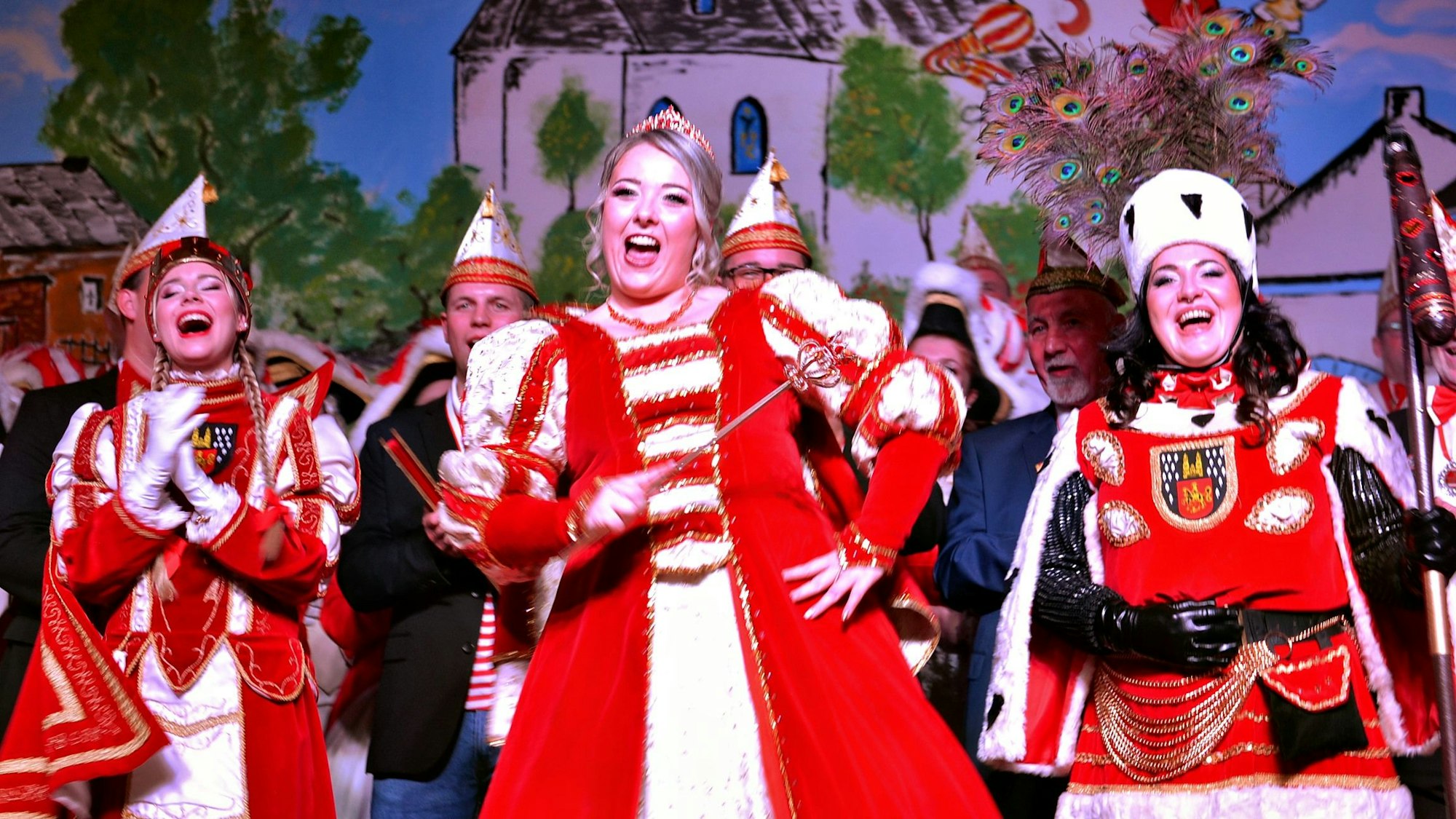 Ein gut gelauntes Damen-Dreigestirn steht lachend und singend auf der Bühne.