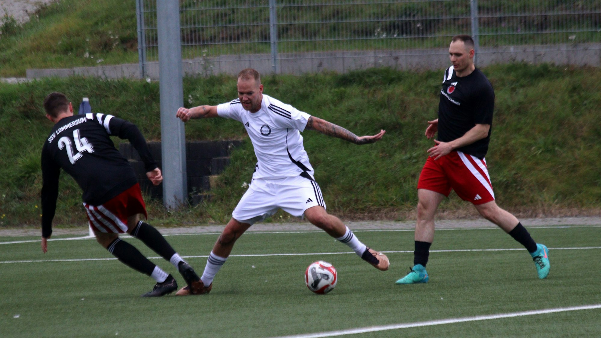 Ein Fußballspieler wird im Strafraum von einem Gegner am Fußb getroffen.