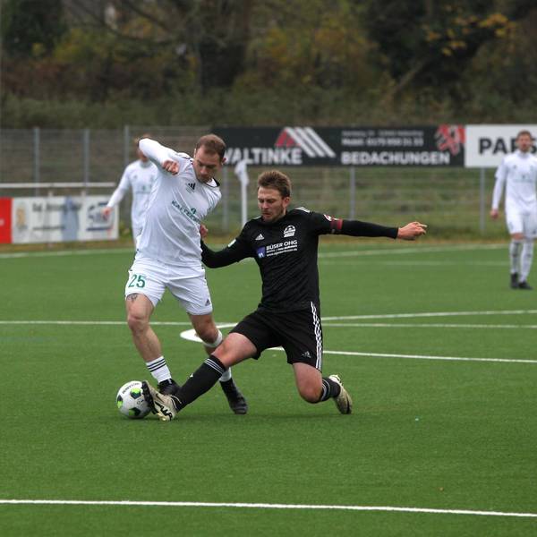 Ein Nierfelder Spieler grätscht einem Gegenspieler den Ball weg.