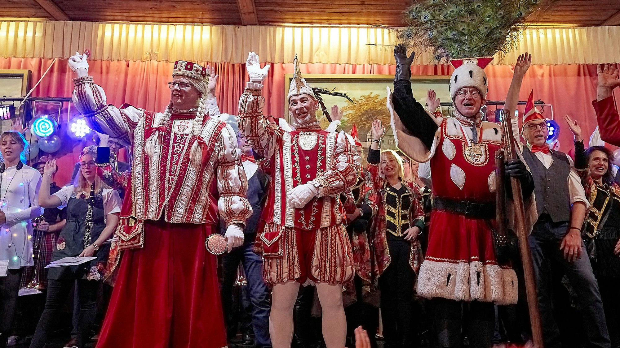 Ein Dreigestirn steht singend und winkend auf der Bühne.