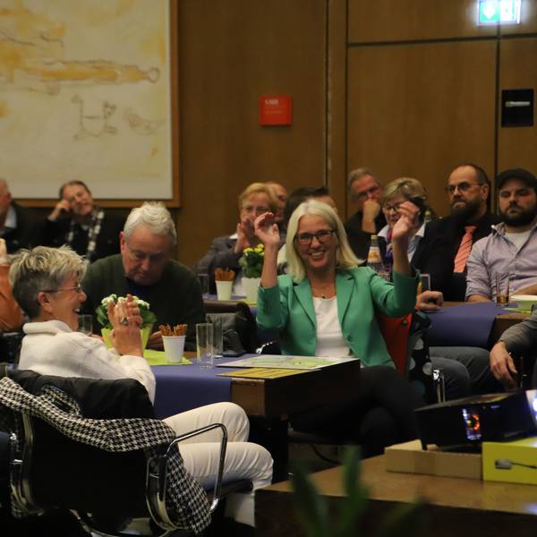 Eine Gruppe freut sich inmitten einer Versammlung über eine positive Nachricht.