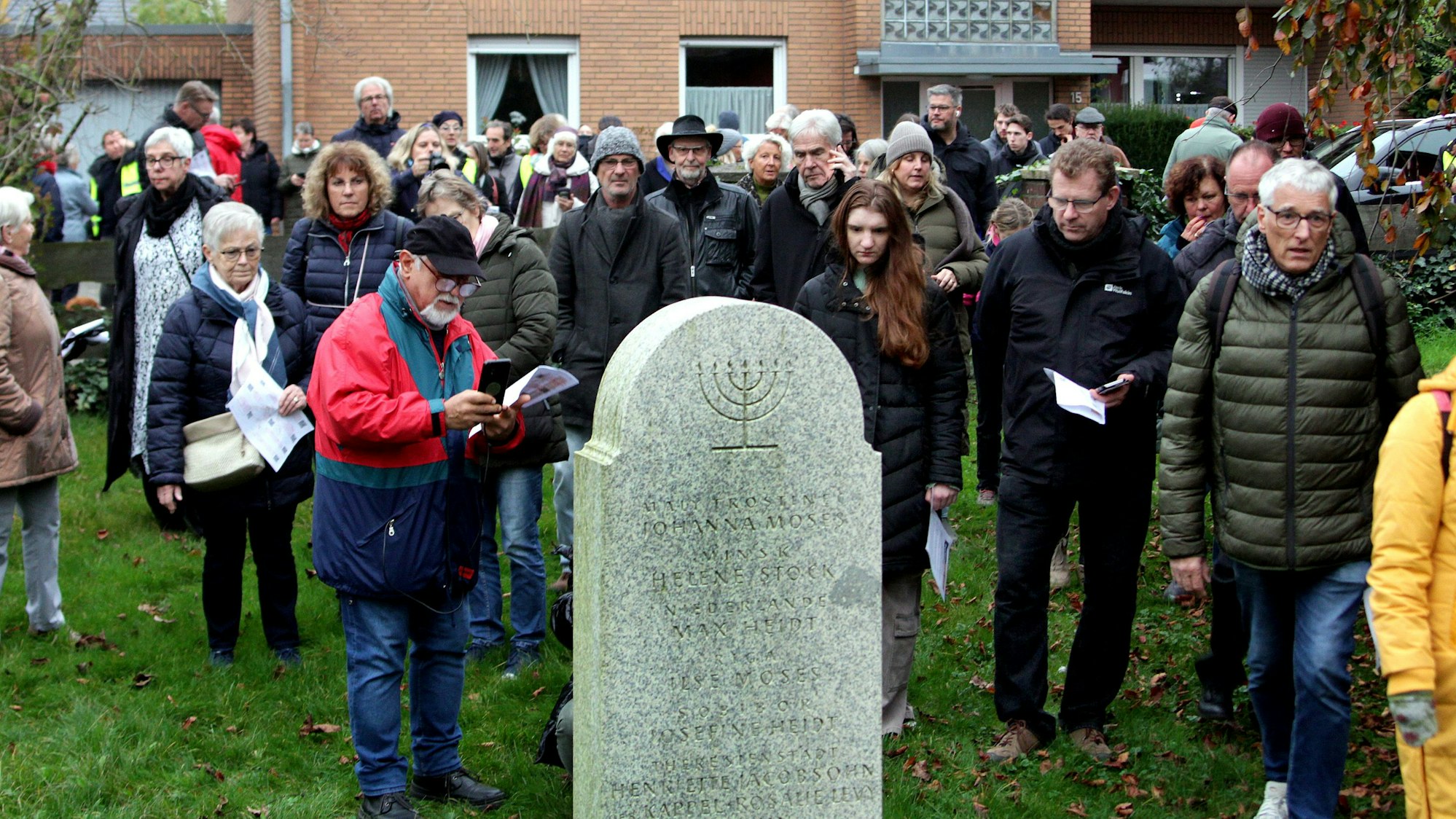 Das Foto zeigt eine große Gruppe von Menschen vor einem Gedenkstein auf dem jüdischen Friedhof in Stommeln.