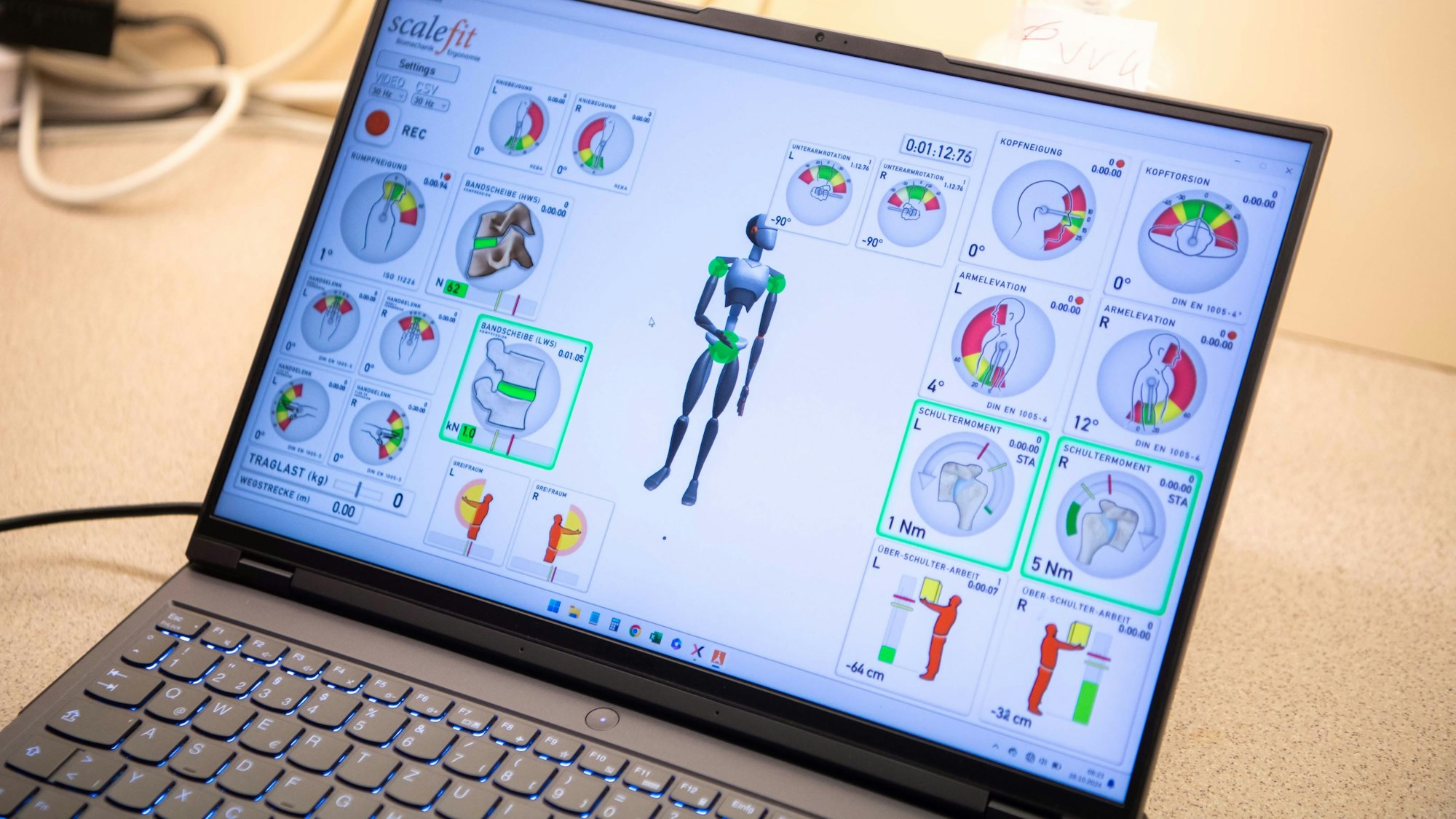 Auf einem Laptopmonitor sind Grafiken zu den Bewegungsabläufen der Pflegekraft zu sehen.