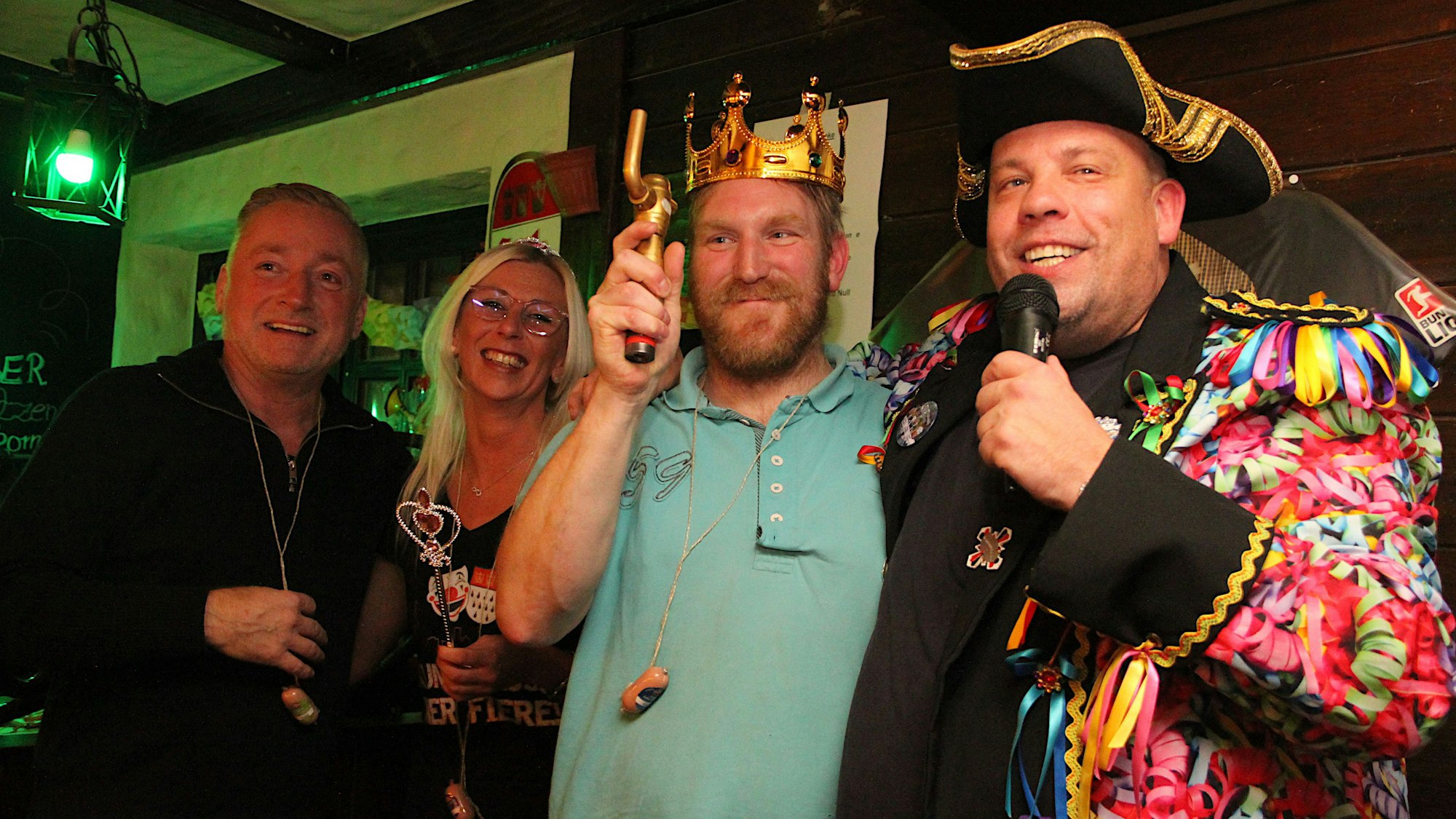 Jeck kostümierte, gut gelaunte Menschen stehen beieinander.