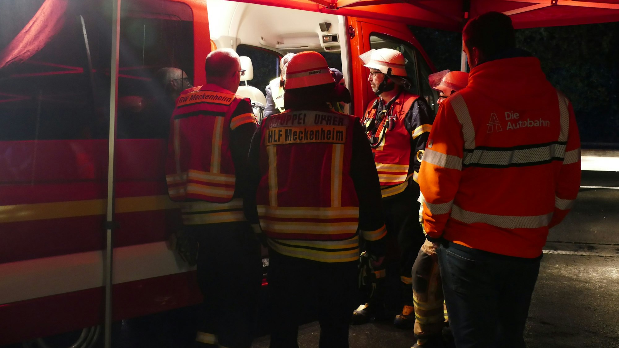 Feuerwehrleute warten am Einsatzleitwagen auf die Fachfirma, die den Lkw leerpumpen soll.