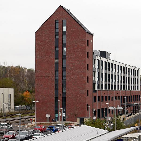 Ein Backsteingebäude steht in der Nähe von Bahngleisen.