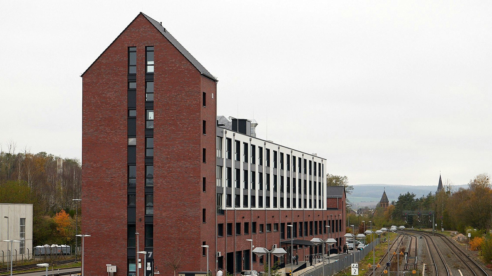 Ein Backsteingebäude steht in der Nähe von Bahngleisen.