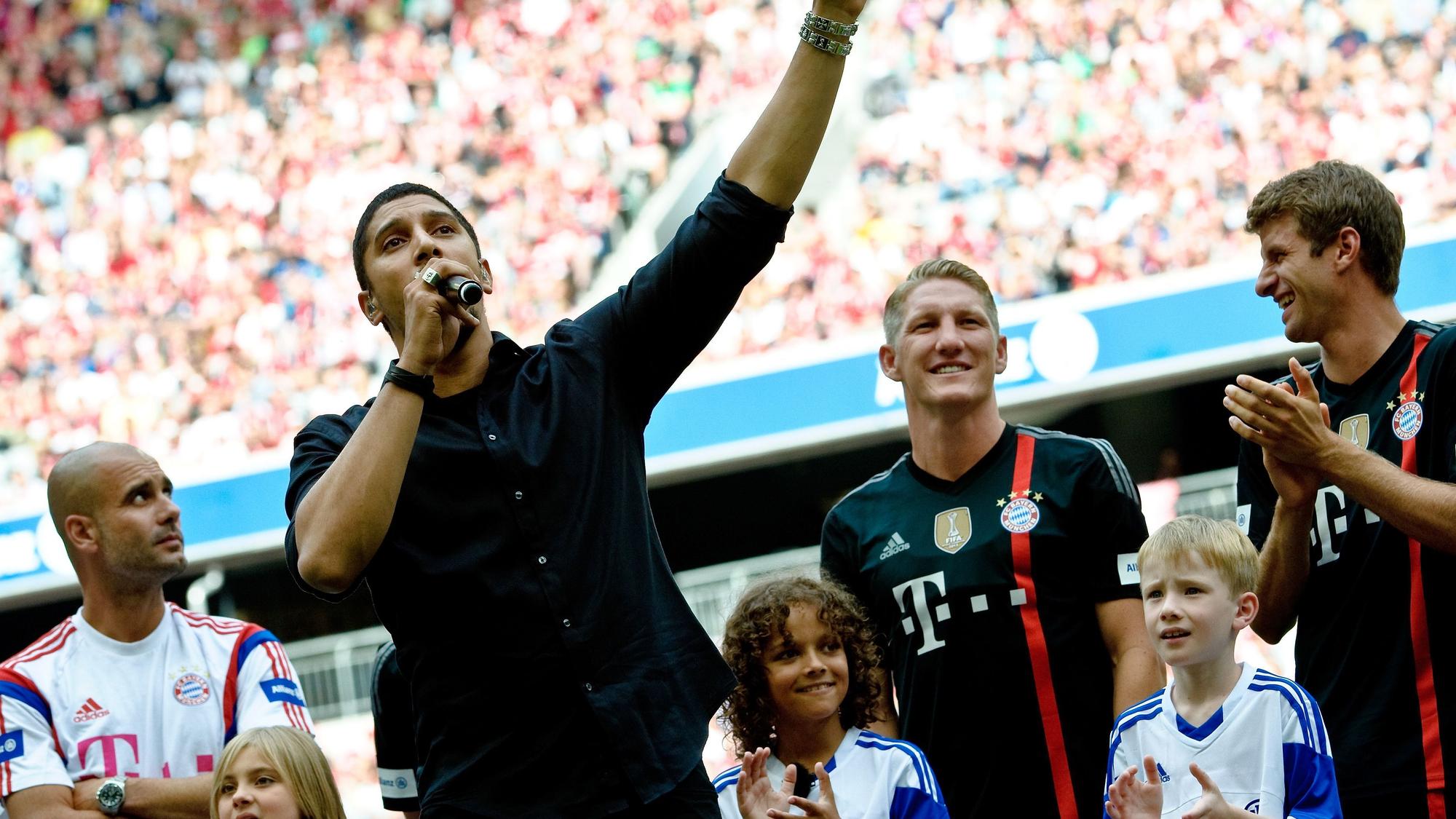 Andreas Bourani (vorne) trat im August 2014 bei der Teampräsentation des Fußball-Bundesligisten FC Bayern München in der Allianz Arena auf. Hinter ihm stehen Bayerns Trainer Pep Guardiola (l-r), Bastian Schweinsteiger und Thomas Müller.