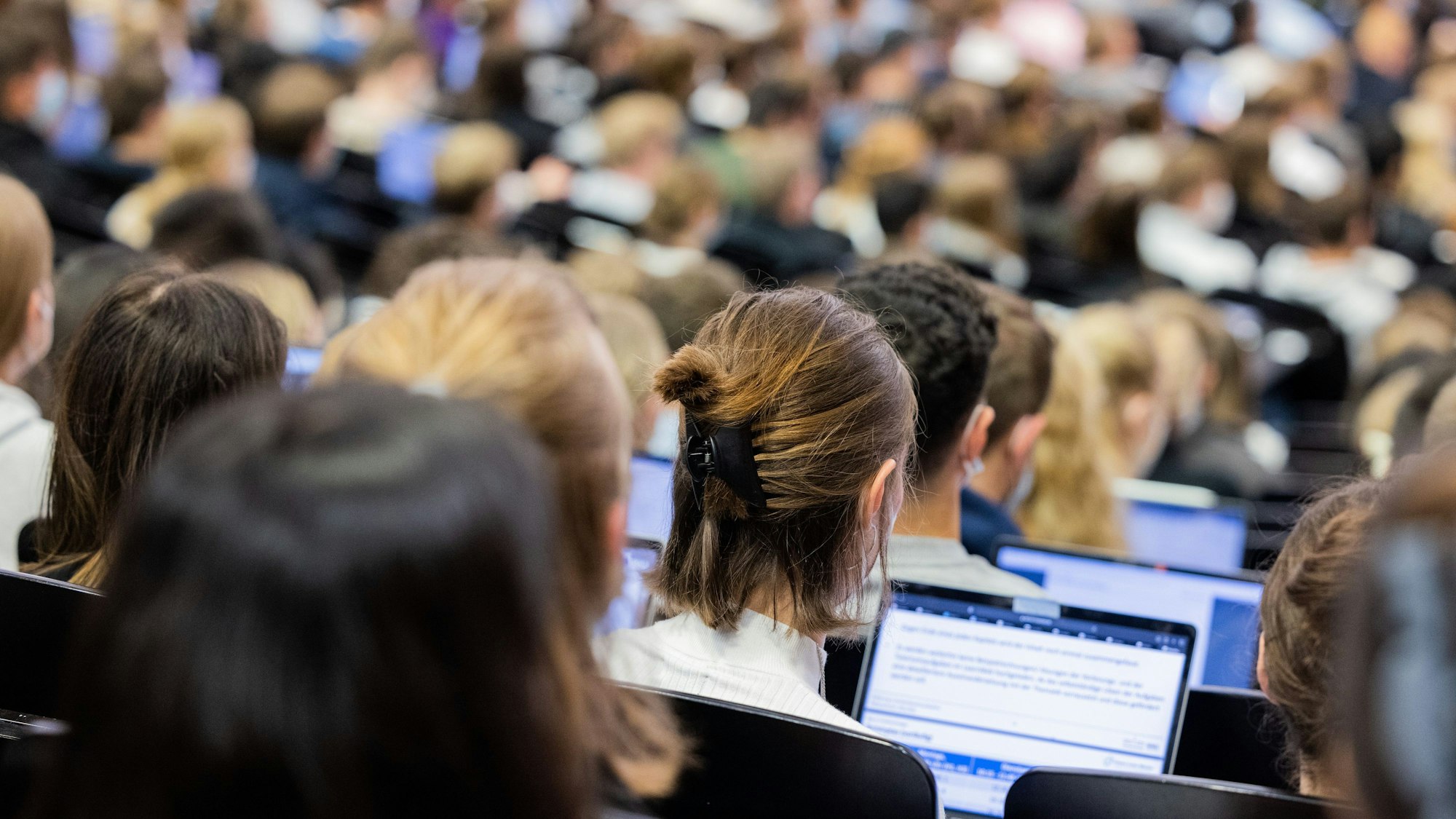 Studentinnen und Studenten sitzen während einer Vorlesung in einem Hörsaal der Uni in Münster.