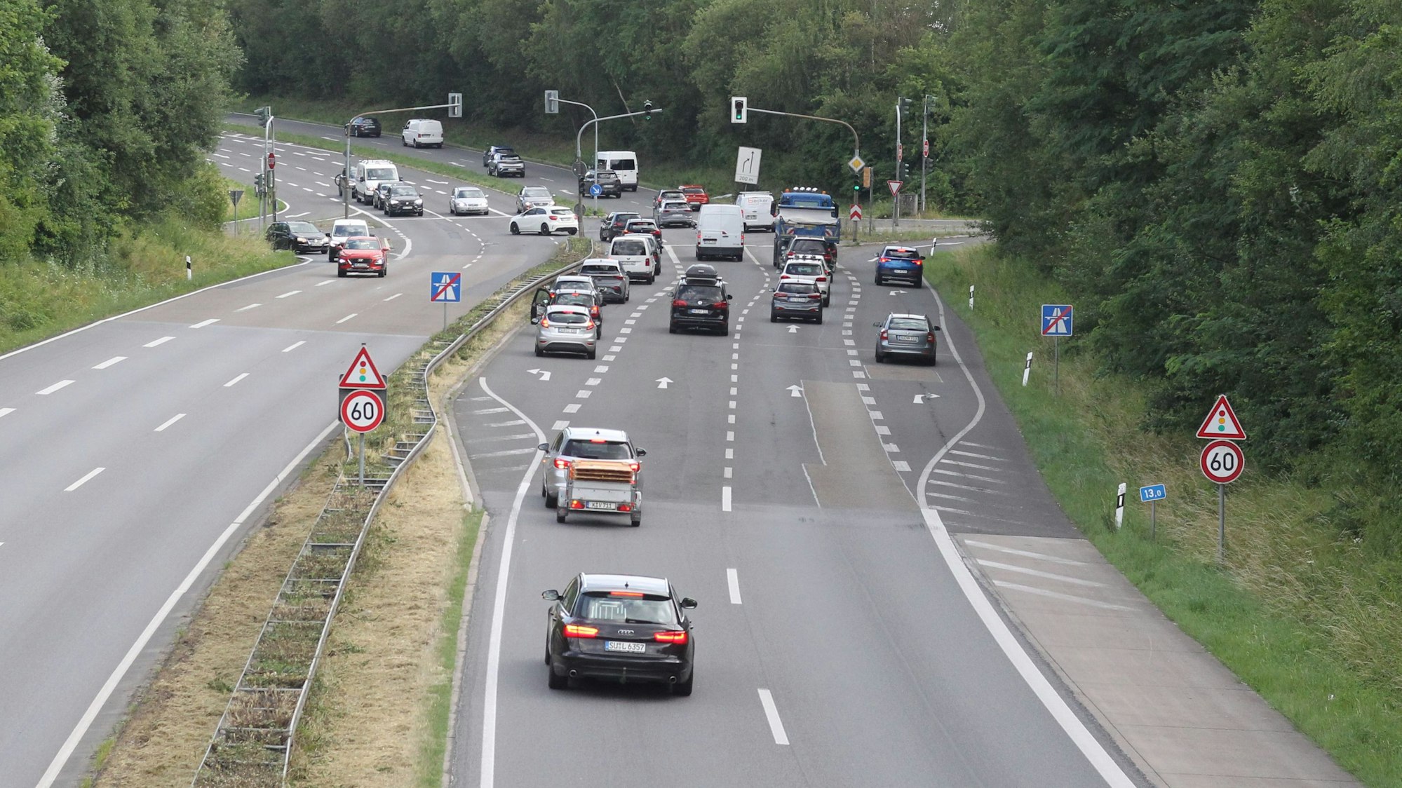 Blick auf das Autobahnende mit etlichen Autos, die sich vor einer Ampel stauen.