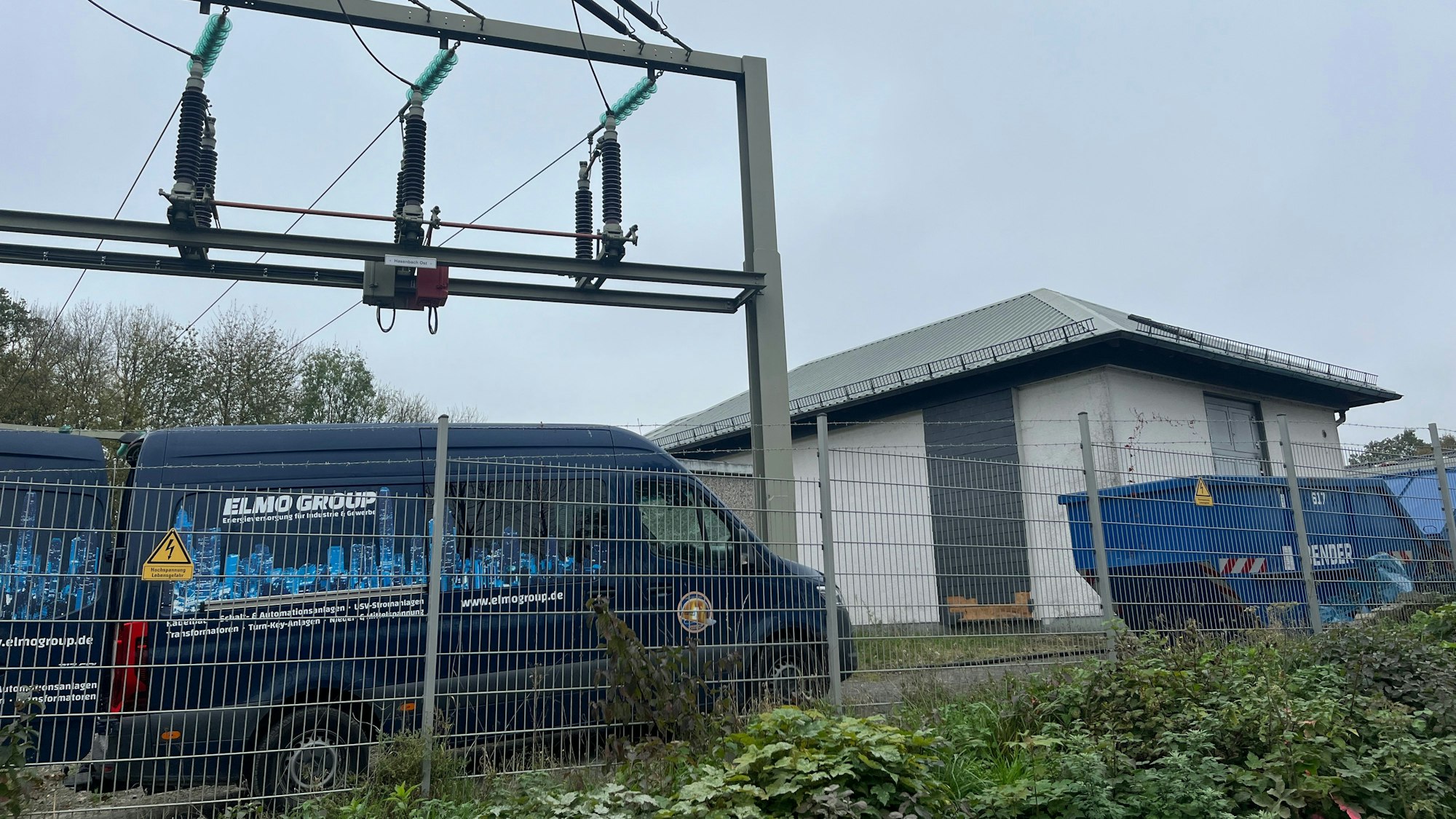 Servicefahrzeuge stehen vor einer Strom-Umspannstation.