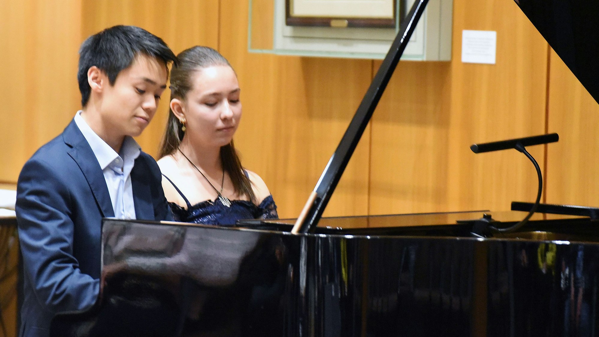 Eine junge Frau und ein junger Mann sitzen zusammen am Flügel.