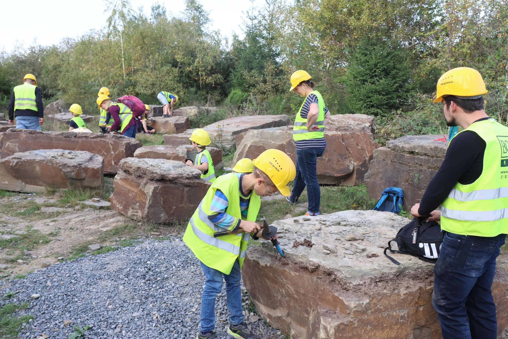 Fossiliensuche mit Hammer und Meißel in einem Lindlarer Grauwacke-Steinbruch.
