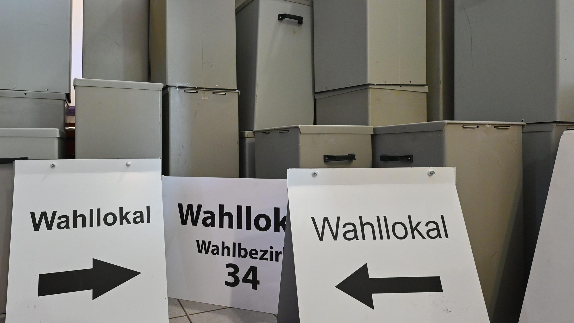 Wahlurnen und -schilder stehen in einem Lager.