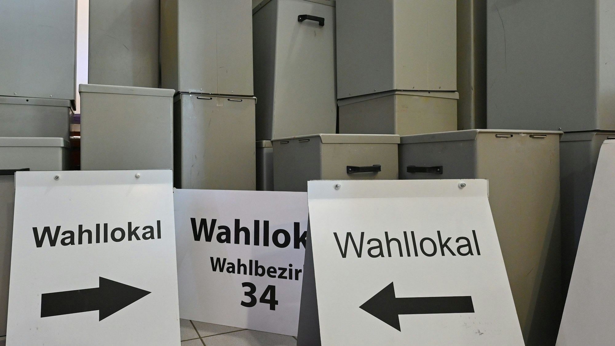 Wahlurnen und -schilder stehen in einem Lager.