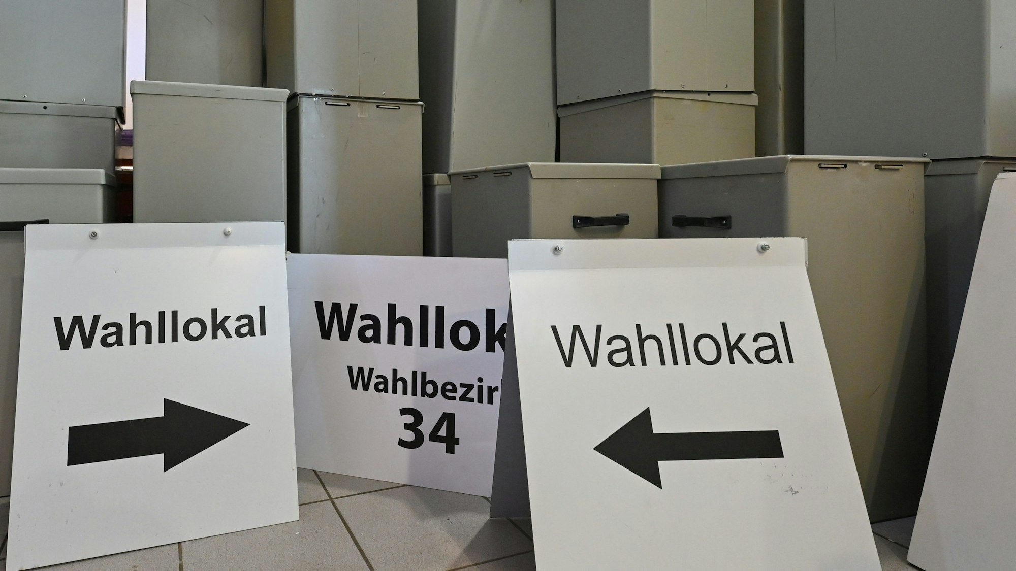 Wahlurnen und -schilder stehen in einem Lager. (Symbolbild)