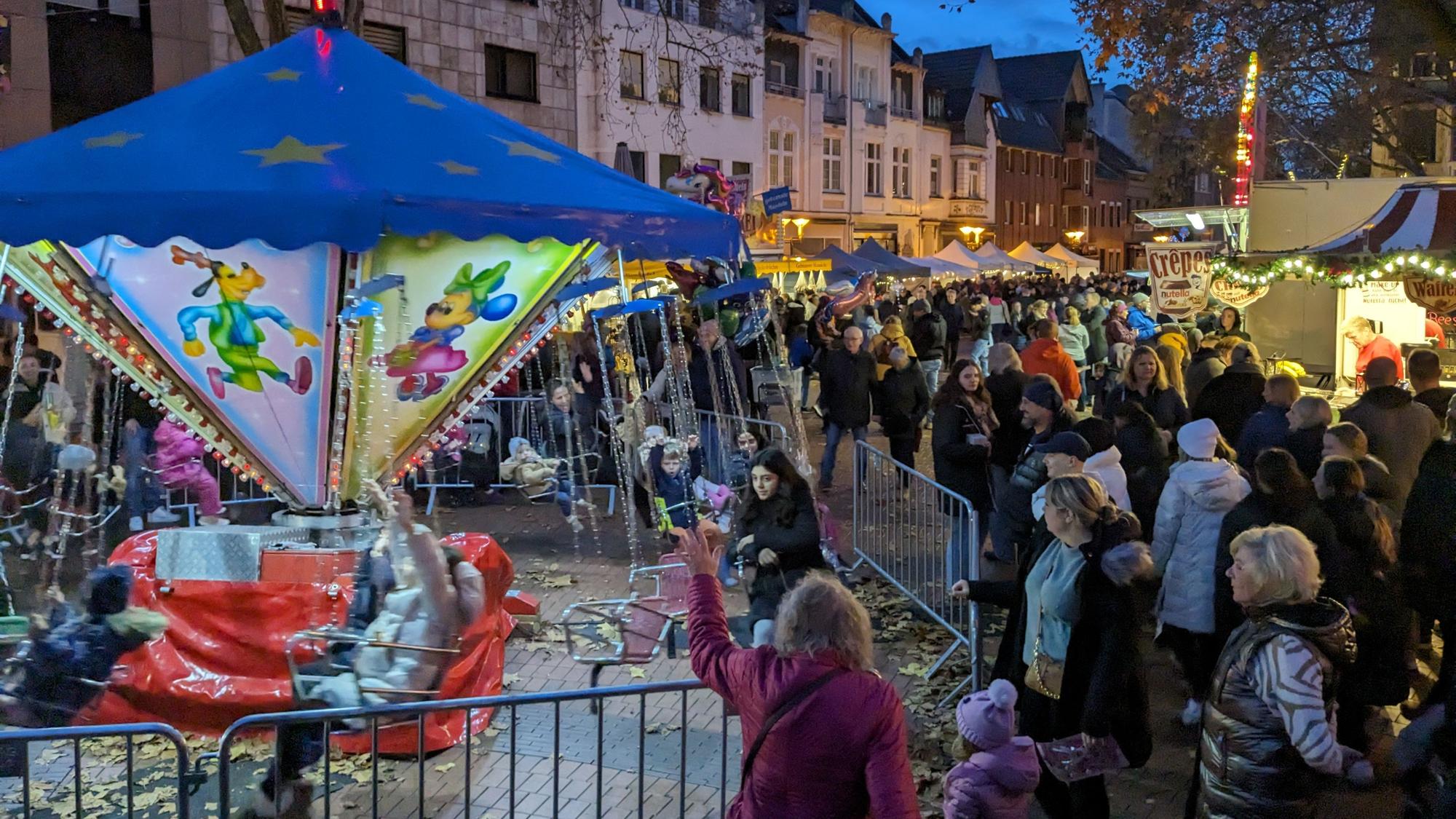 Auf dem Bild sind die Besucher des Martinsmarkts im vergangenen Jahr und ein Karussell zu sehen.