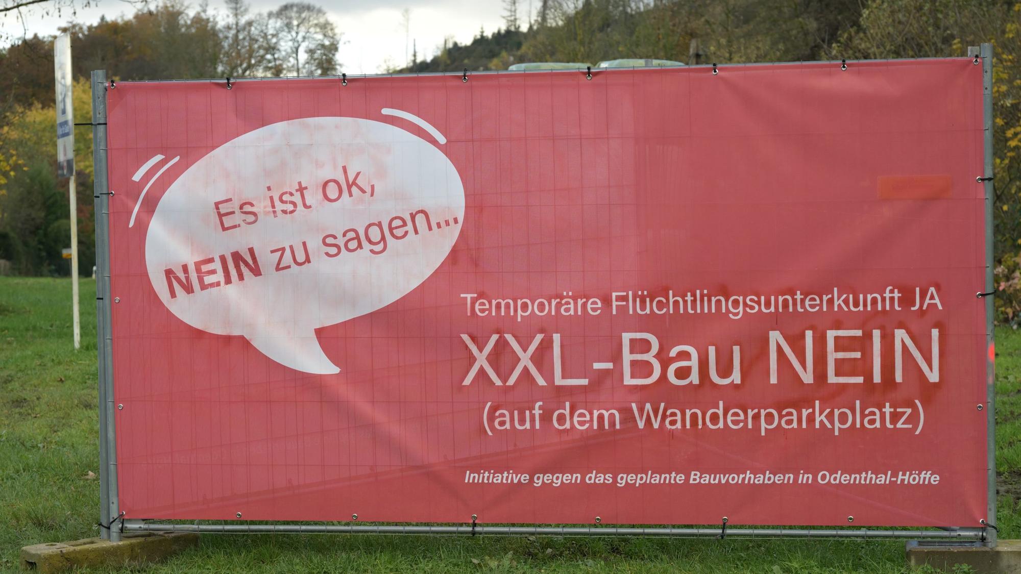 Ein rotes Protestplakat gegen den Bau einer Flüchtlingsunterkunft.