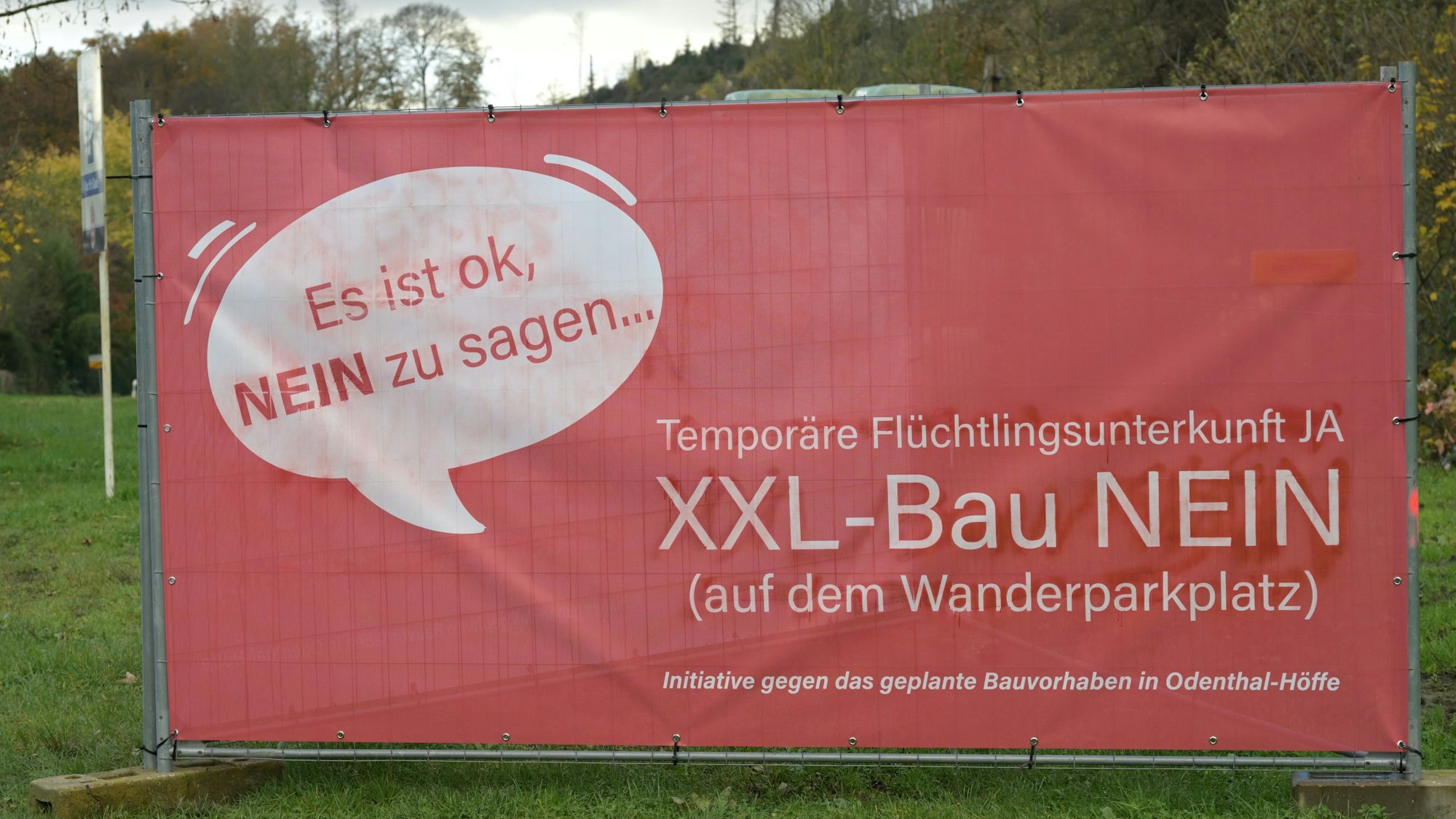 Ein rotes Protestplakat gegen den Bau einer Flüchtlingsunterkunft.