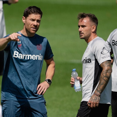 Leverkusens Trainer Xabi Alonso (l) spricht mit Aleix Garcia.