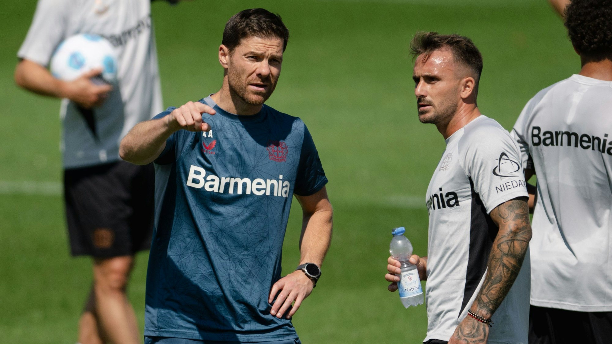 Leverkusens Trainer Xabi Alonso (l) spricht mit Aleix Garcia.