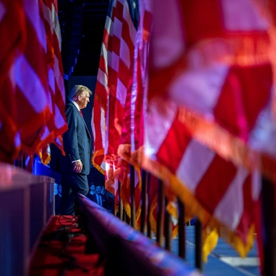 Donald Trump läuft einen Spalier aus US-Flaggen entlang.