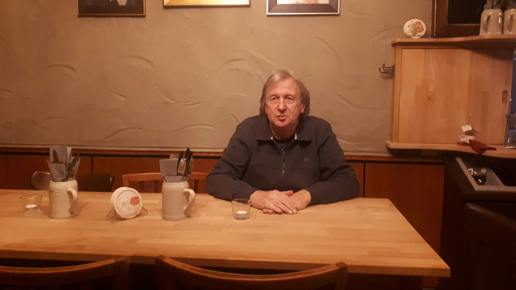 Mann sitzt an einem Tisch in einem Gasthaus.