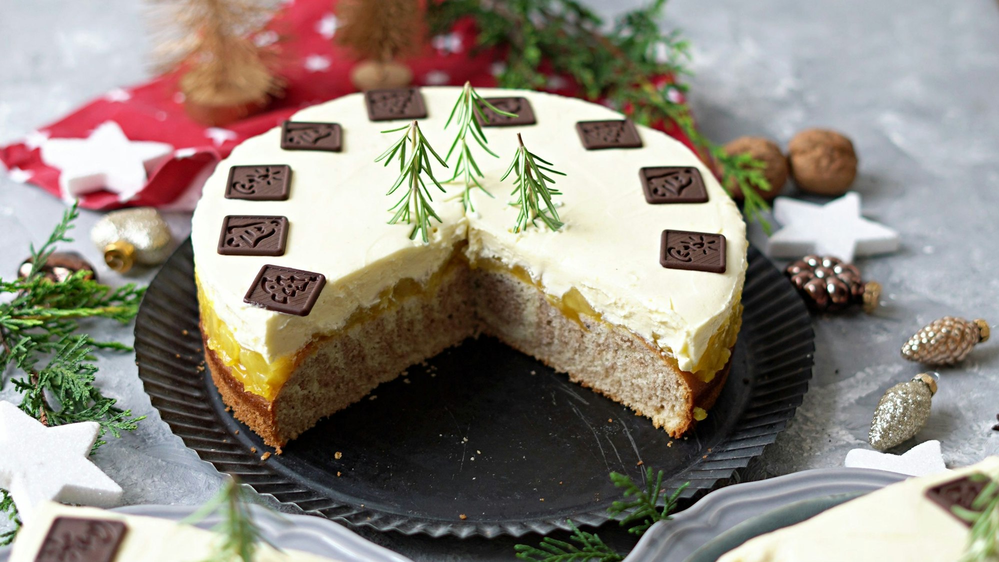 Die Torte ist mit Schokotäfelchen und Rosmarinzweige dekoriert.