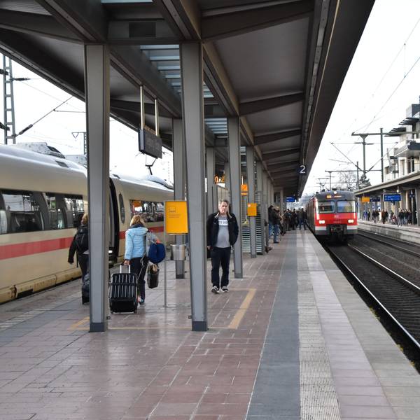Ein Regionalzug fährt in den Siegburger Bahnhof auf Gleis 2 ein, einige Menschen stehen am Gleis.