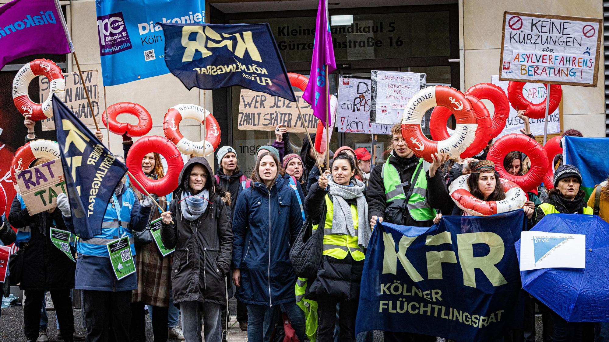 Menschen mit Schwimmringen und Plakate demonstrieren.