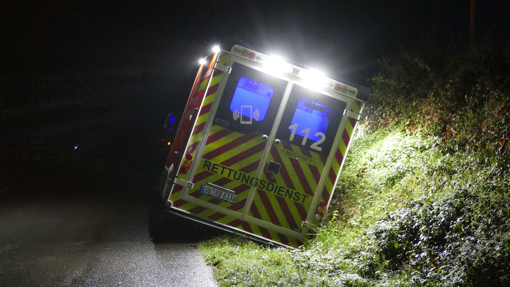 Ein Rettungswagen liegt auf der Seite im Graben.