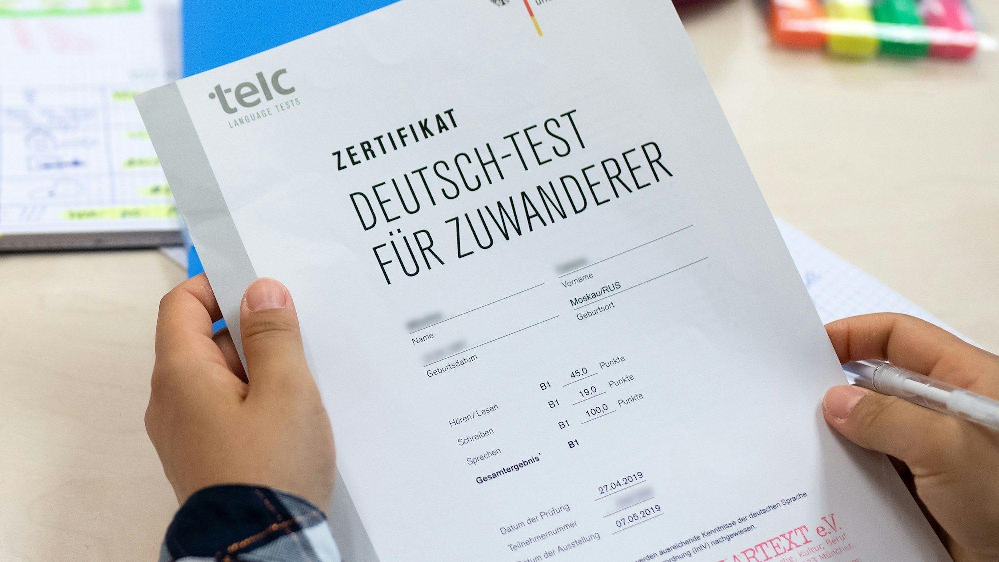 Eine Kursteilnehmerin freut sich über ihr Zertifikat „Deutsch-Test für Zuwanderer“, das sie für die erfolgreiche Teilnahme an einem Integrationskurs für Zuwandererbekommen hat.
