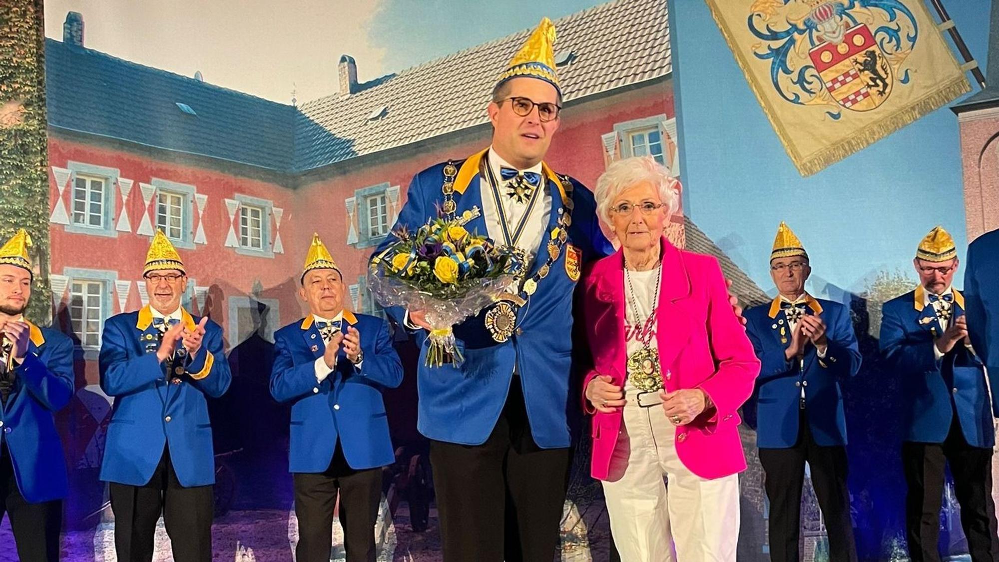 Karola Dänner steht neben Sven Hinterwälder, der einen Strauß Blumen hält.
