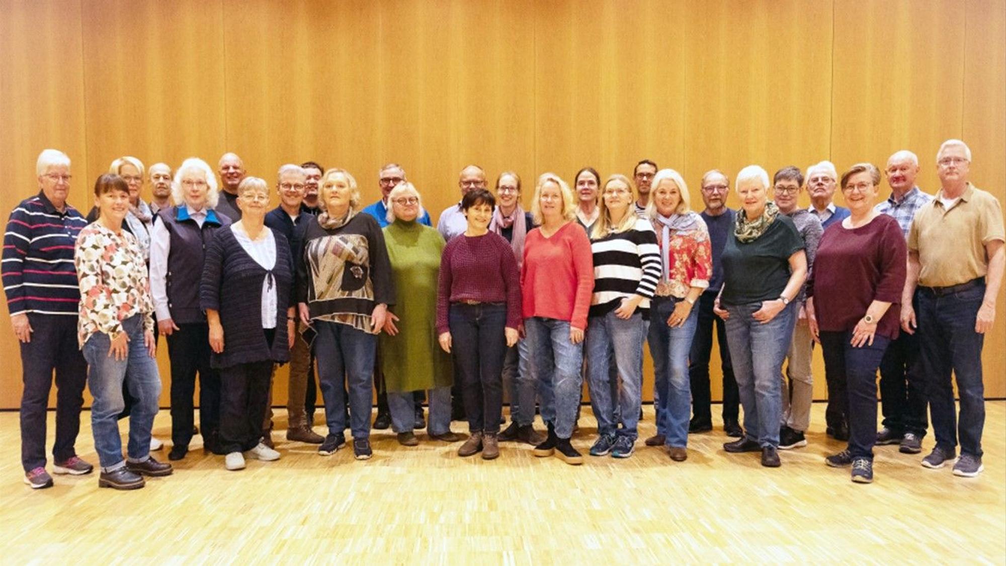 Männer und Frauen stehen in einer Gruppe zusammen.