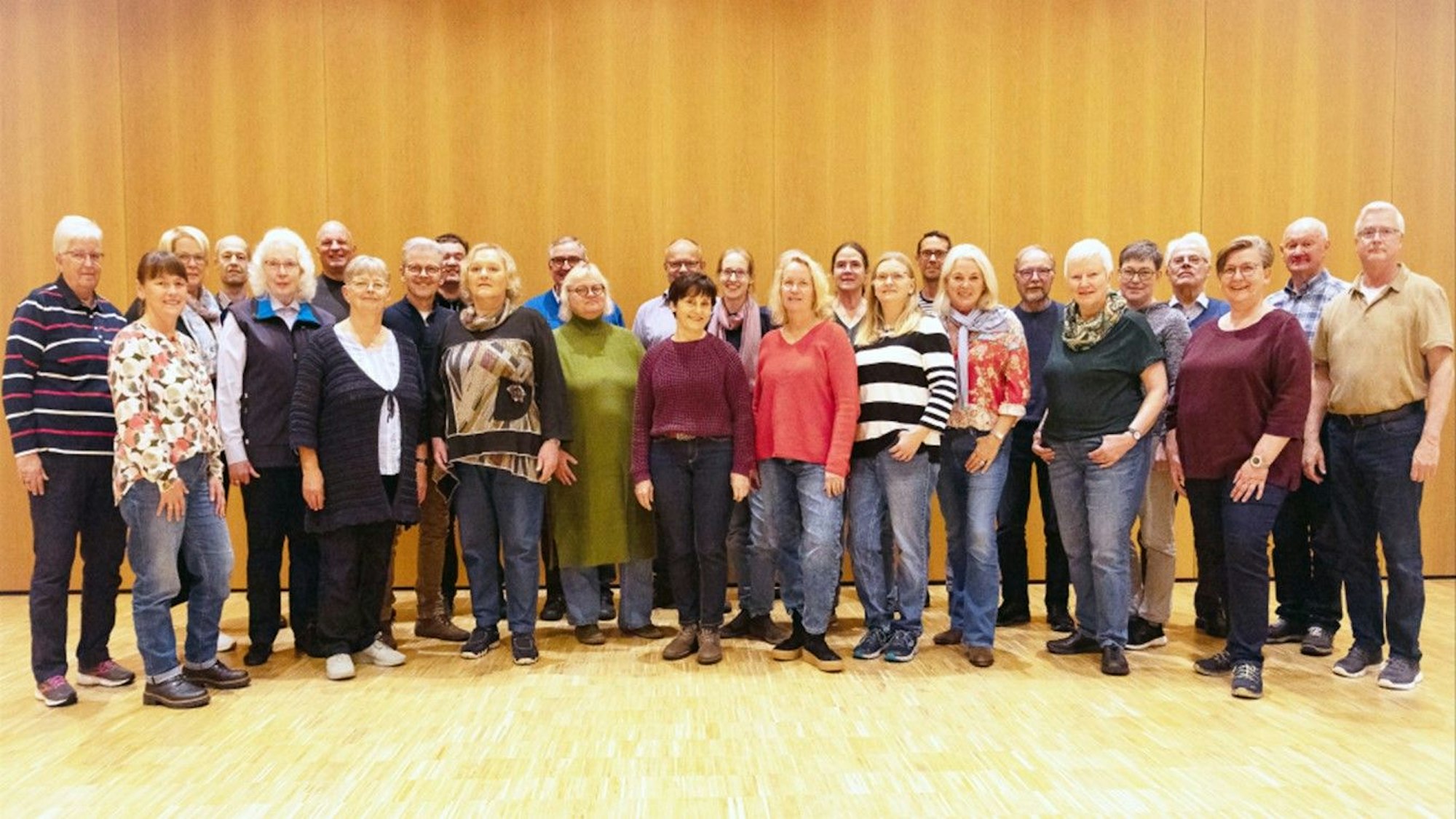 Männer und Frauen stehen in einer Gruppe zusammen.