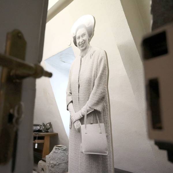Blick an einer halb geöffneten Tür vorbei in einen Raum, in dem eine lebensgroße Figur von Queen Elizabeth steht.